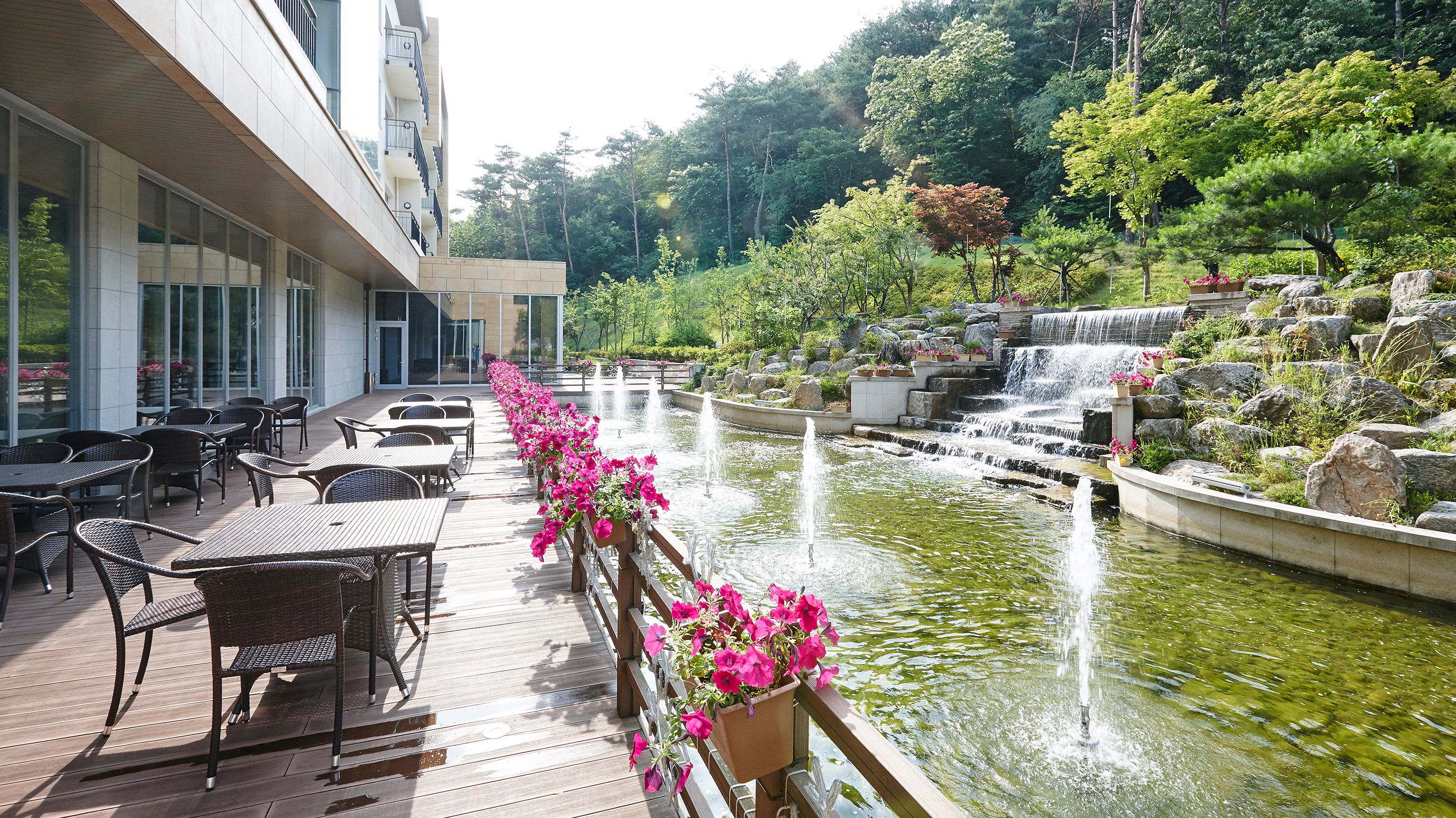A deck with outdoor seating and a small waterfall.