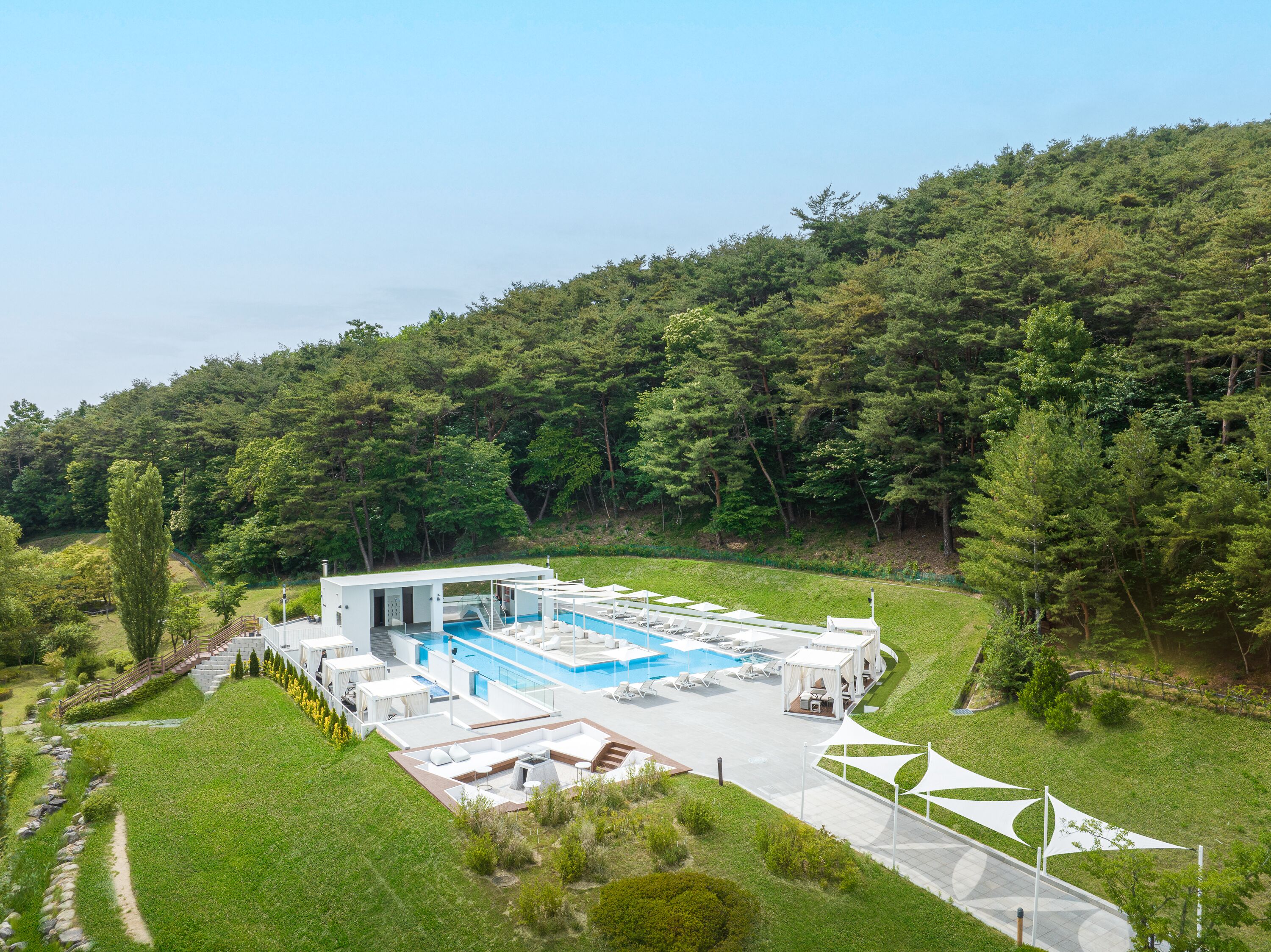 Un área de piscina exterior moderna con vistas despejadas del bosque circundante.