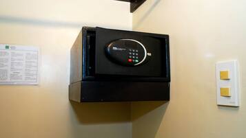 Una caja fuerte negra fijada a la pared, con un panel de control.