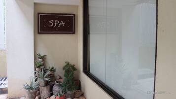 Un cartel de spa, plantas en macetas y una ventana con vistas al exterior.
