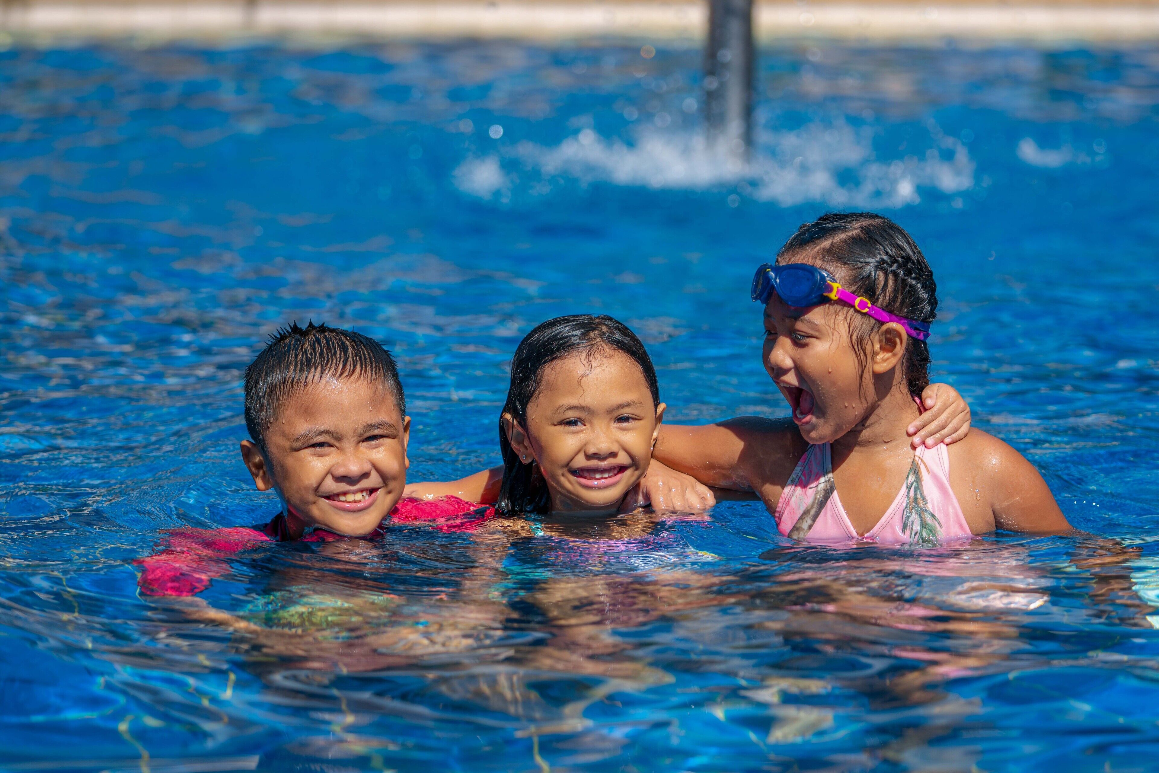 Three children in a swimming pool.