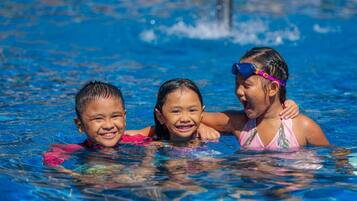 Tres niños en una piscina.