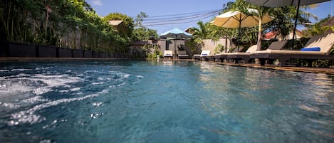 Piscine extérieure, parasols de plage, chaises longues