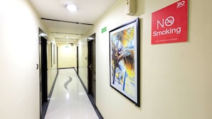 A hotel corridor with a 'No Smoking' sign, a framed abstract painting, and a '20 Rooms' sign. - Acacia Inn (Jaipur)