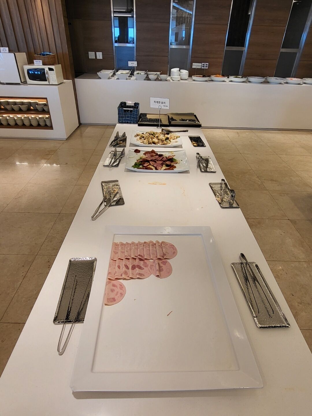 A buffet setup with various dishes and utensils.