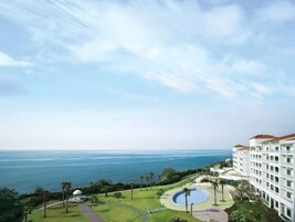 A resort with a large pool, a gazebo, and a view of the ocean.