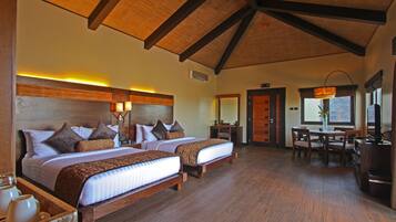 A hotel room with two beds, a dining area, and a kitchen.