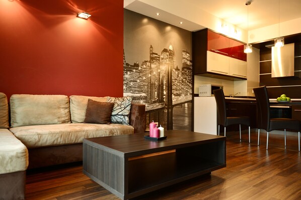 A modern living room with a sofa, a coffee table, and a cityscape mural on the wall.