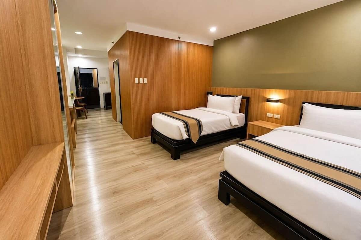 Ein Hotelzimmer mit einer Holzwandverkleidung, einem Bett mit Kopfteil, einem Nachttisch und einem Beistelltisch.