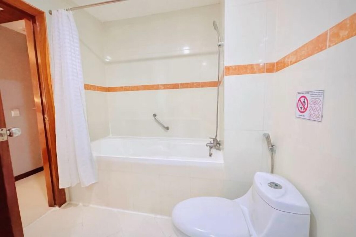 A bathroom with a bathtub, toilet, and shower.