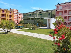 A hotel courtyard with a central pathway, surrounded by multi-story buildings with balconies.