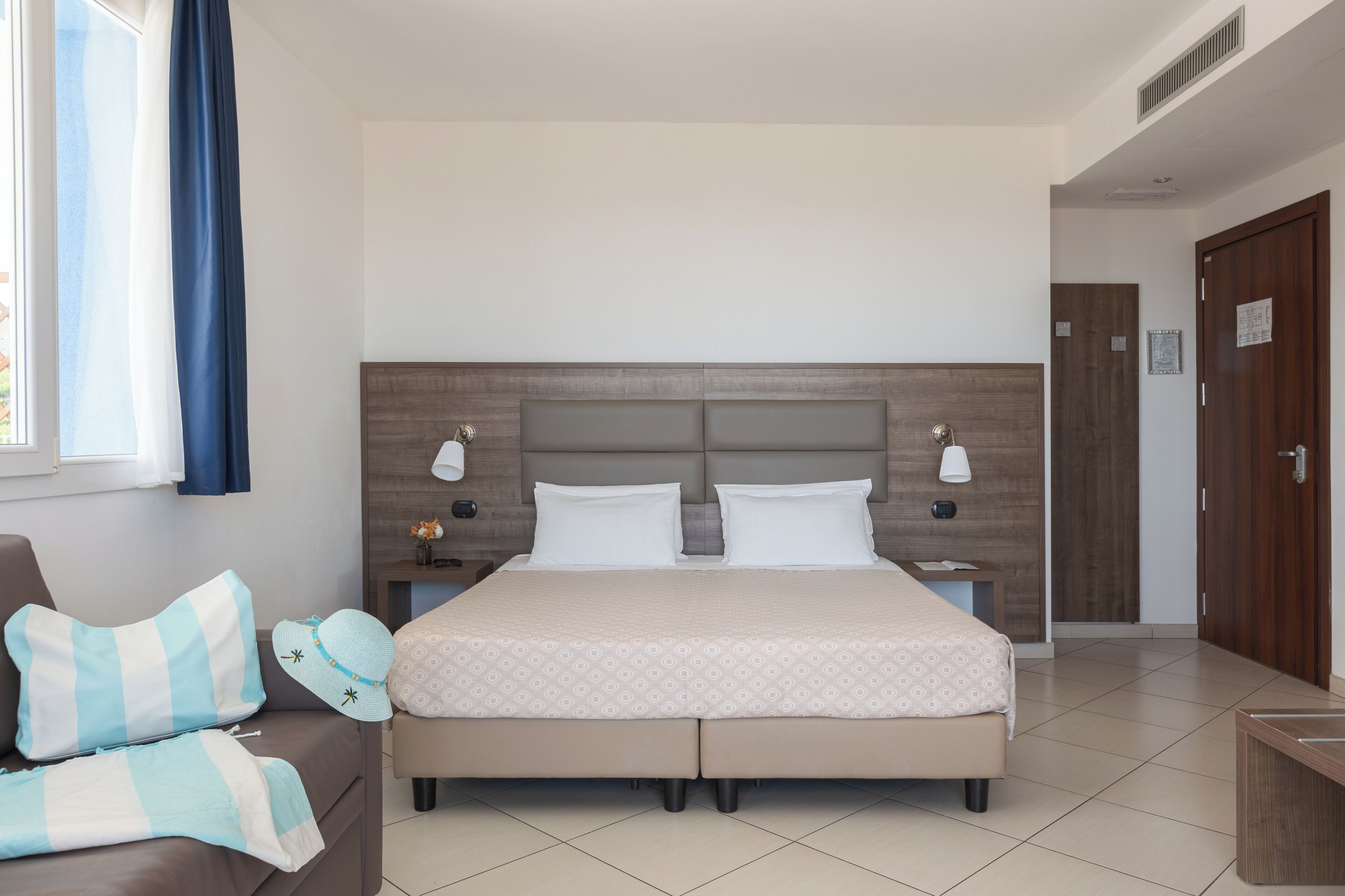 Una camera da letto ordinata con un letto grande, comodini e una finestra con tende.