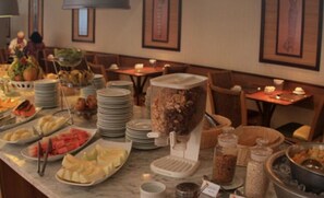 A buffet setup with various food items and condiments. - Aquários Praia Hotel (Aracaju)
