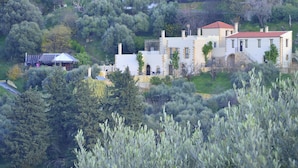 A hillside villa with multiple buildings, surrounded by dense greenery and trees. - Maria Villas (Kissamos)