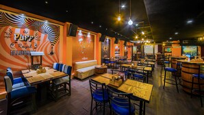A restaurant with booths, tables, and a bar area. - LYNQ CICO (Kolkata)