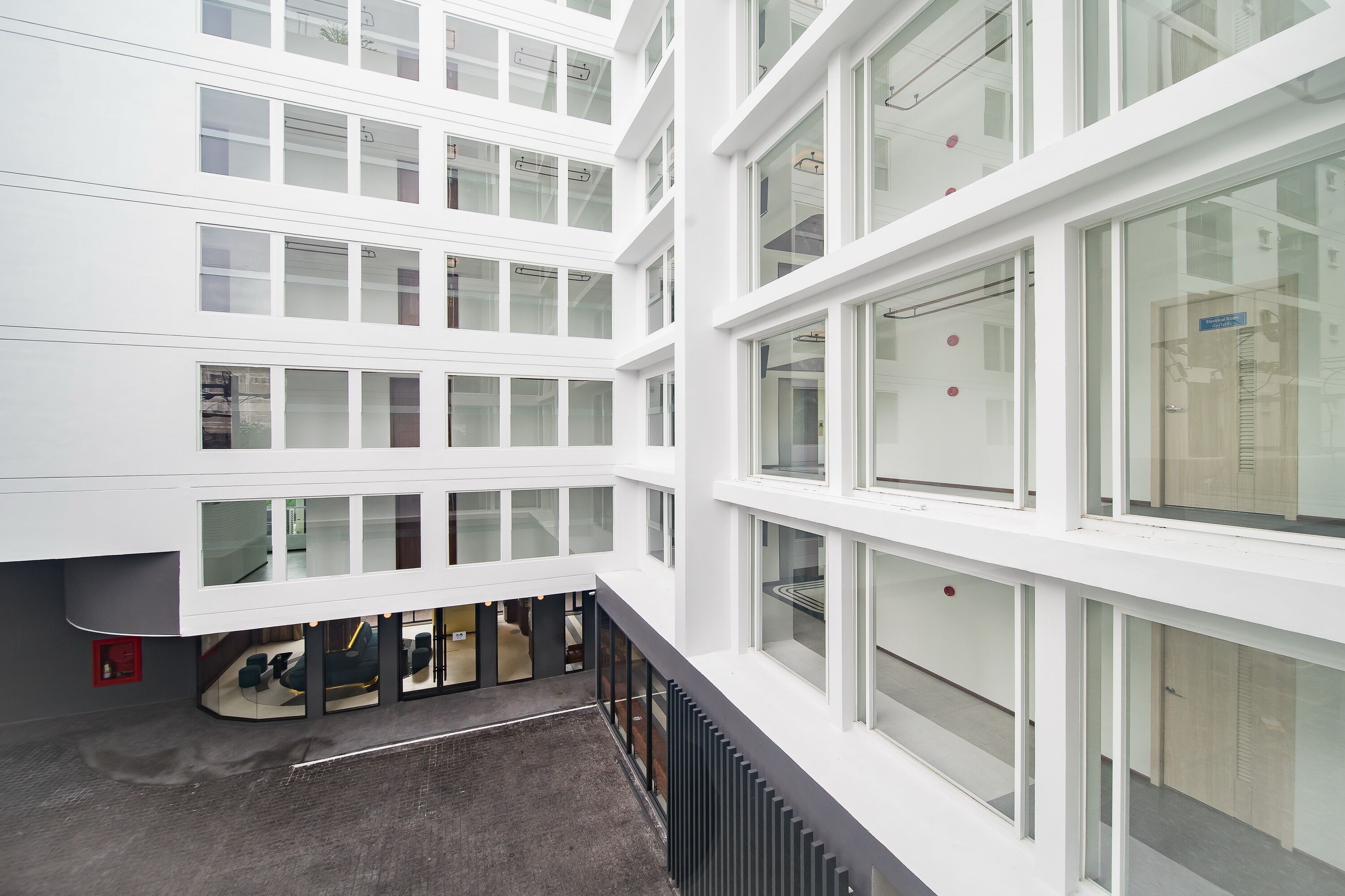 A multi-story building with large windows and a covered outdoor area.