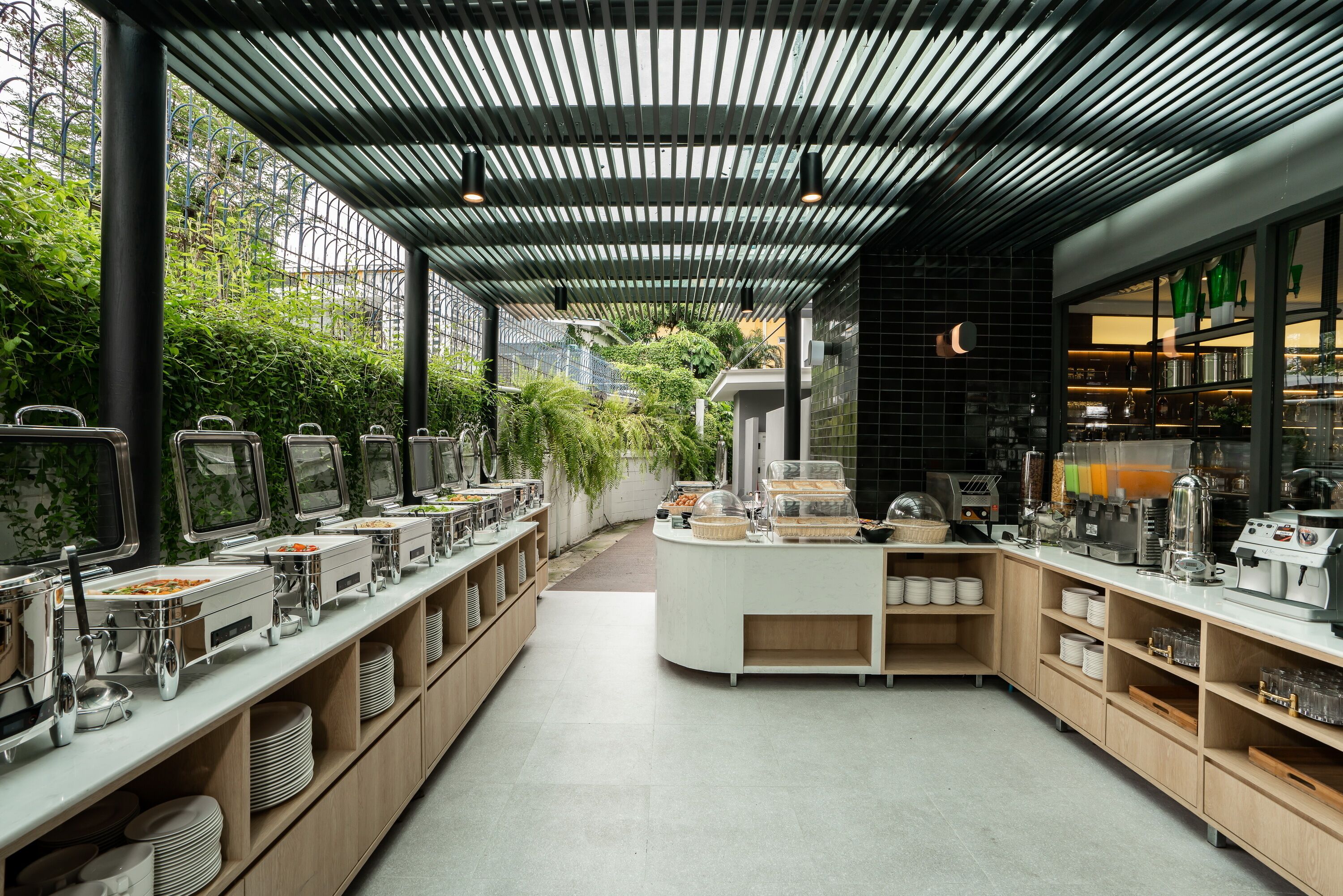 A modern kitchen with a long counter, various appliances, and a coffee station.