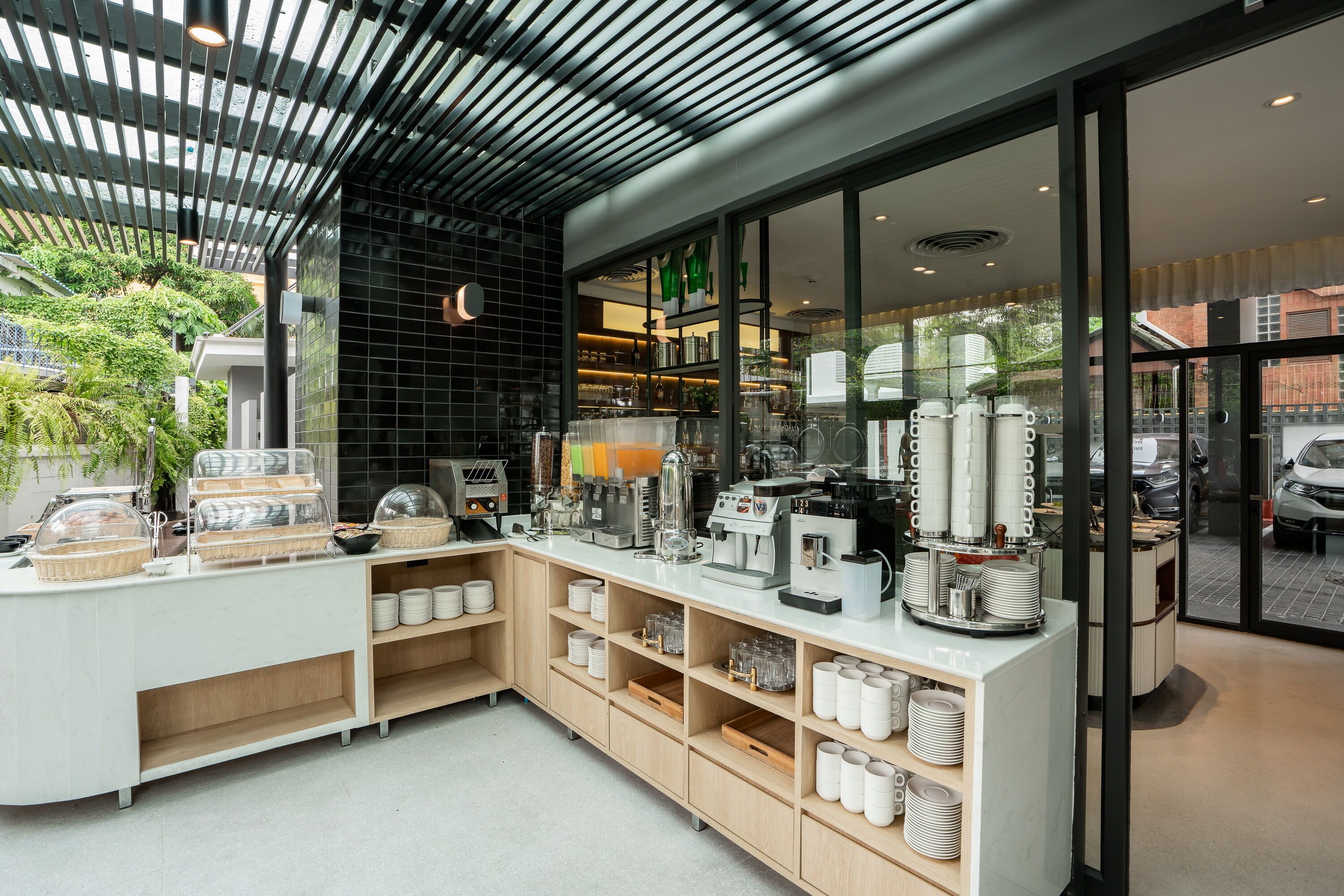 Un café moderne avec un comptoir où sont exposées différentes machines à café et une vitrine réfrigérée.
