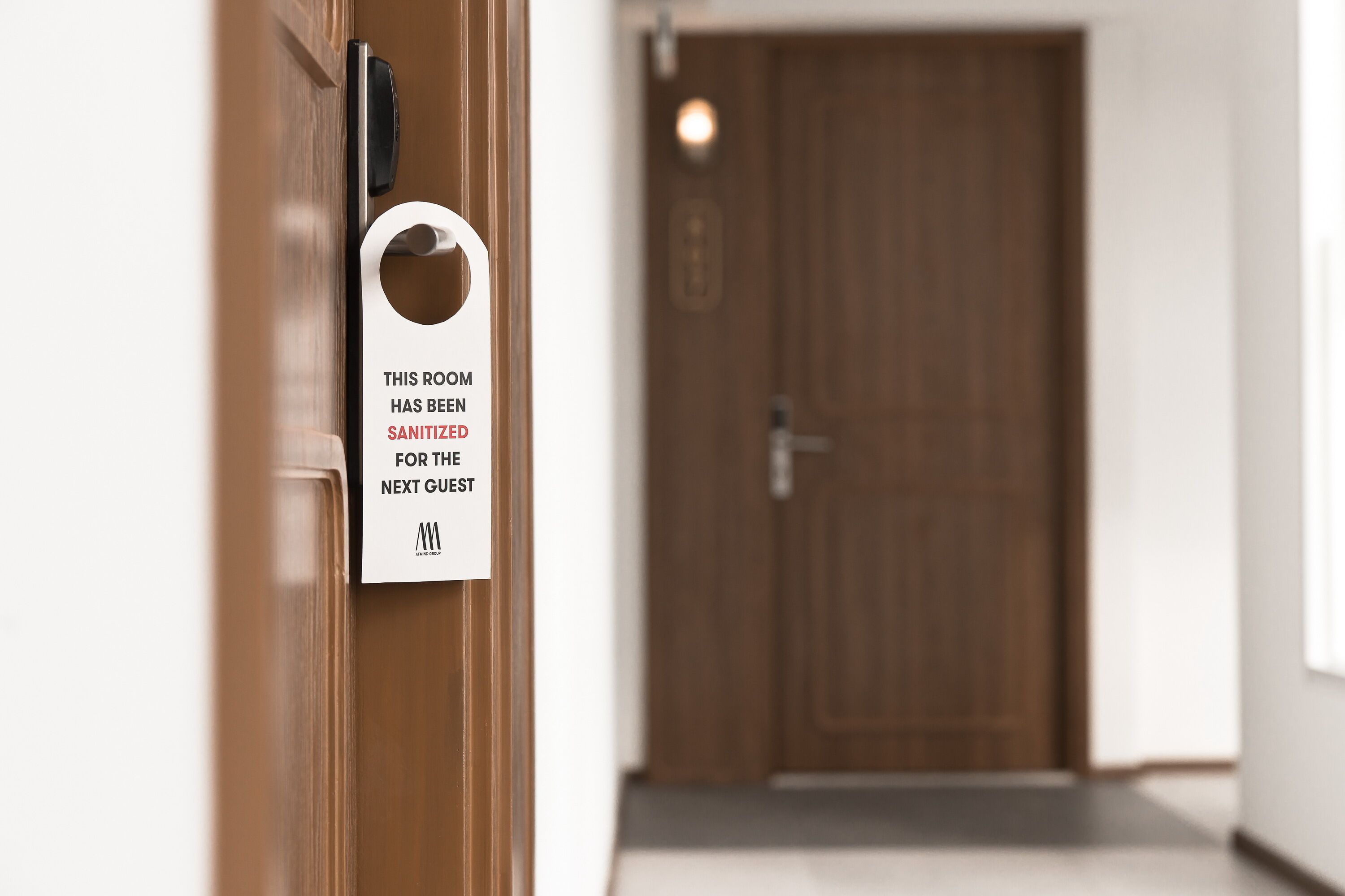 A hotel room door with a sign stating the room has been sanitized for the next guest.