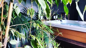 A spa area with a hot tub surrounded by various plants and greenery. - Solar Quinta da Portela (Santa Marta de Penaguião)