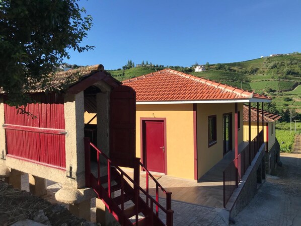 Un edificio con una puerta y una escalera roja que llevan a un porche.