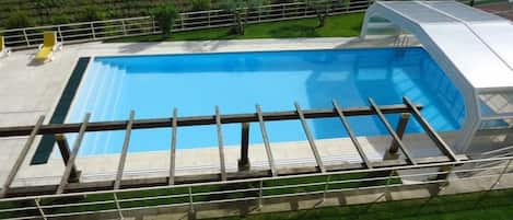 Piscine couverte, piscine extérieure, parasols de plage, chaises longues