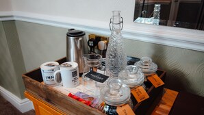 Eine Kaffeestation mit verschiedenen Kaffe- und Teebehältern, einem Thermos und einem Krug.