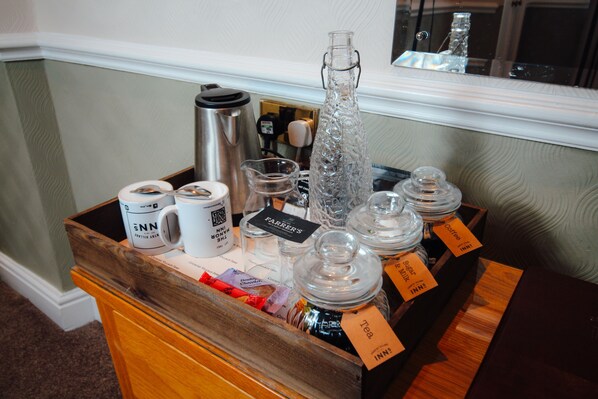 A coffee station with a variety of coffee and tea containers, a thermos, and a pitcher. - The Manor (St Bees)