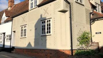 A traditional building with a symmetrical facade, featuring a central window and a chimney.