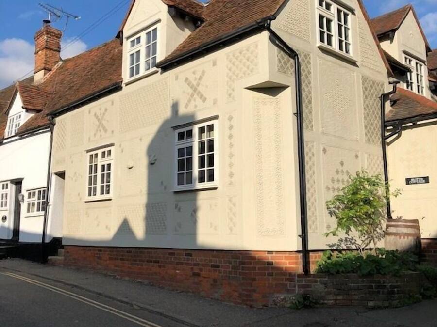 A traditional building with a symmetrical facade, featuring a central window and a chimney.