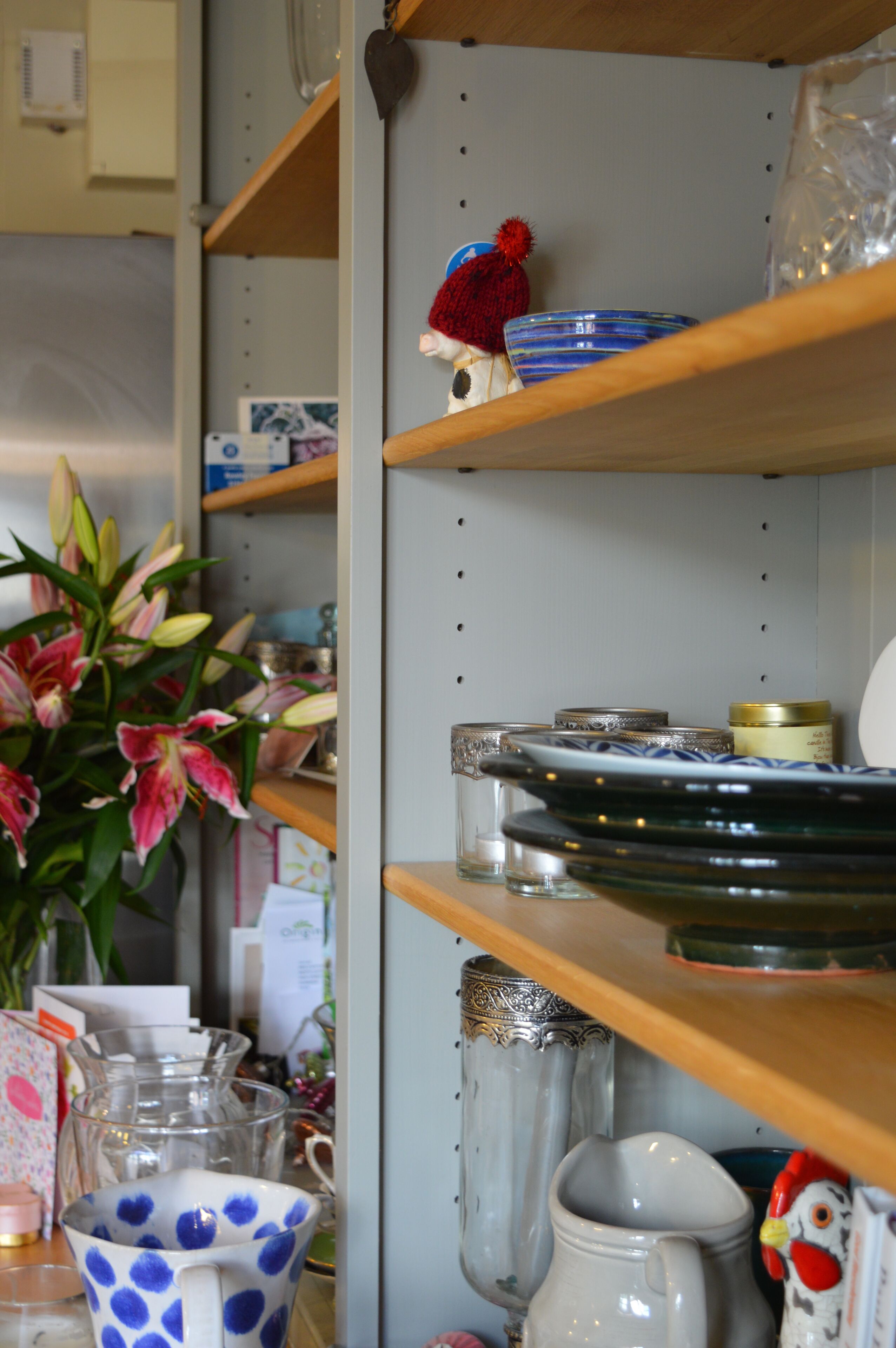 Shelves with various kitchenware, including plates, bowls, and a pitcher.