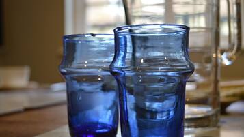 Two blue glass pitchers on a table.