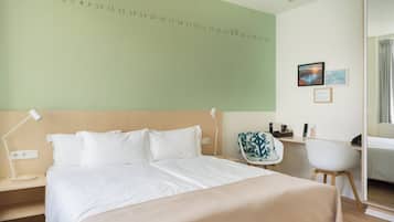 A hotel room with a bed, a desk, a chair, a nightstand, and a wall with a number sequence.