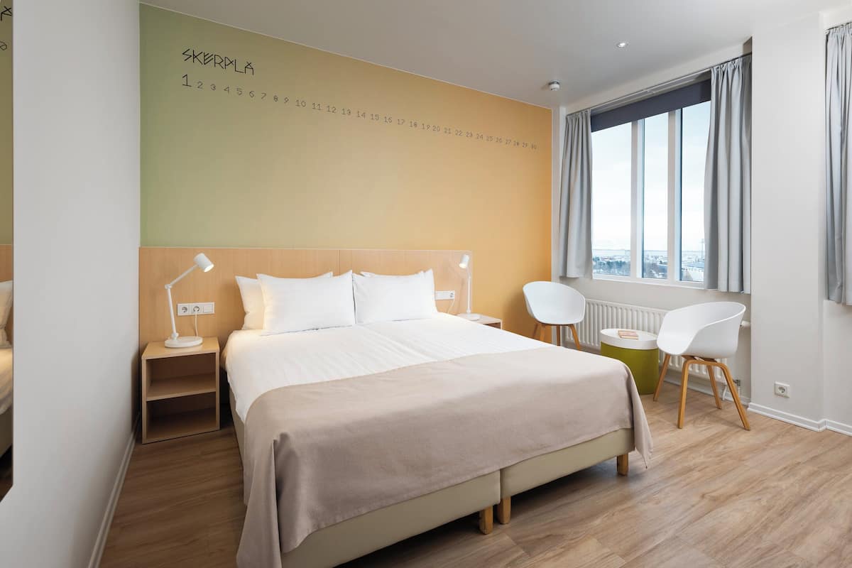 Ropa de cama hipoalergénica y caja de seguridad en la habitación