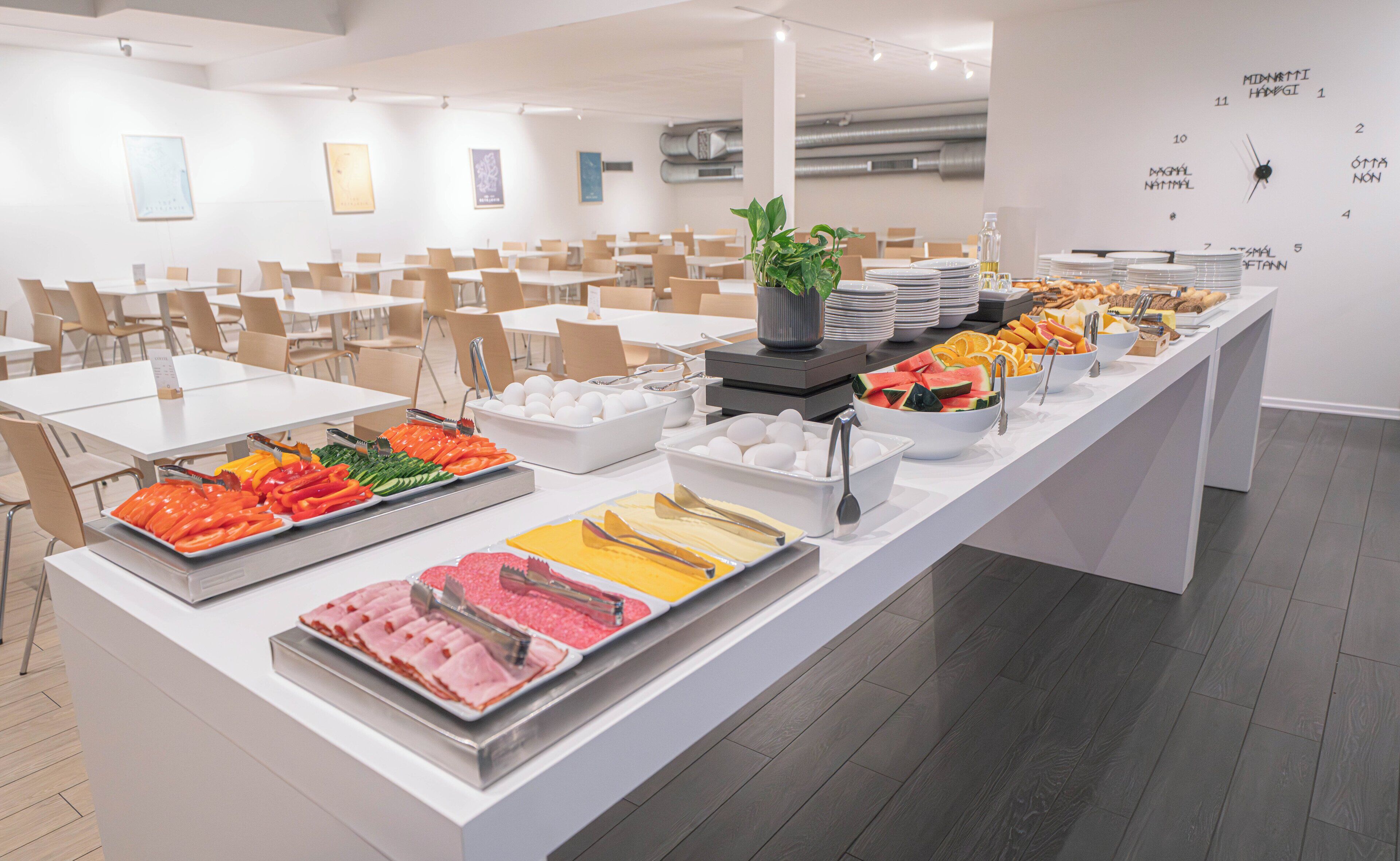 A buffet setup with various food items and a clock on the wall.