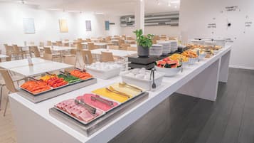 A buffet setup with various food items and a clock on the wall.