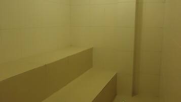 Bathroom features a shower area and a single light fixture.