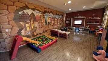 Kids can play and learn in this vibrant room featuring a ball pit, slide, and interactive mural.