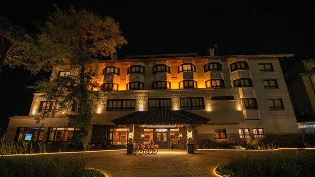 A hotel with a central entrance, a covered waiting area, and a bicycle parking area. - Hotel Serra Nevada (Canela)