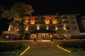 A hotel with a central entrance, a covered waiting area, and a bicycle parking area. - Hotel Serra Nevada (Canela)