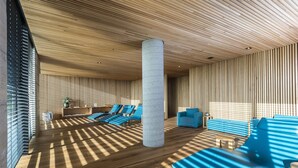 Ein modernes Interieur mit Holzboden, blauen Sitzgelegenheiten und einer zentralen Säule.