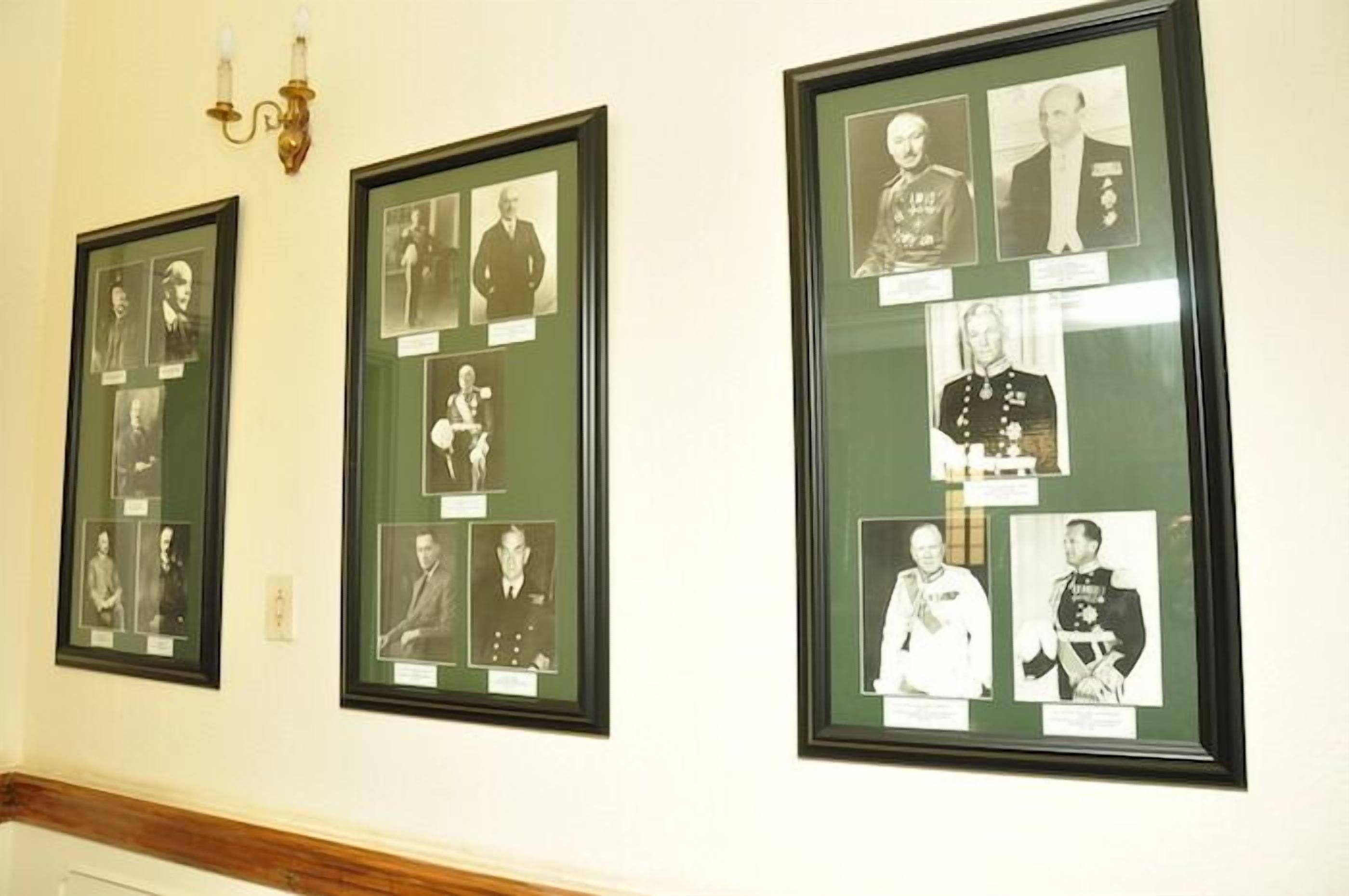 Framed photographs on a wall, likely in a public or institutional setting.