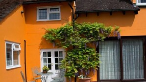 A house with a brick patio, a small table with chairs, and a potted plant. - Woodview Bed & Breakfast (Colchester)