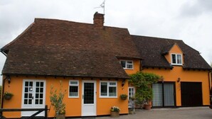 A two-story house with a tiled roof, a front door, and a garage. - Woodview Bed & Breakfast (Colchester)