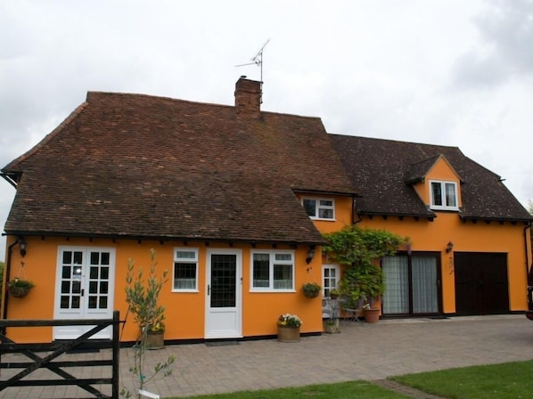 A two-story house with a tiled roof, a front door, and a garage.