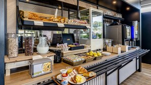 Ein Frühstücksbuffet mit verschiedenen Speisen und einer Kaffeestation.