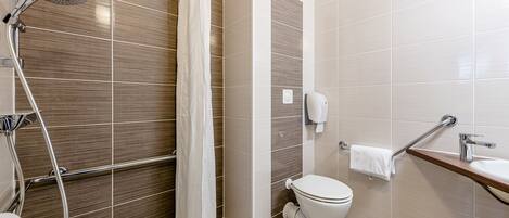 A modern bathroom with a shower, toilet, and sink.