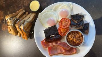 A plate with eggs, bacon, beans, tomatoes, and toast.