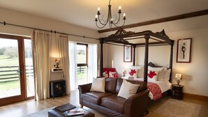 A bedroom with a four-poster bed, a sofa, and a fireplace.