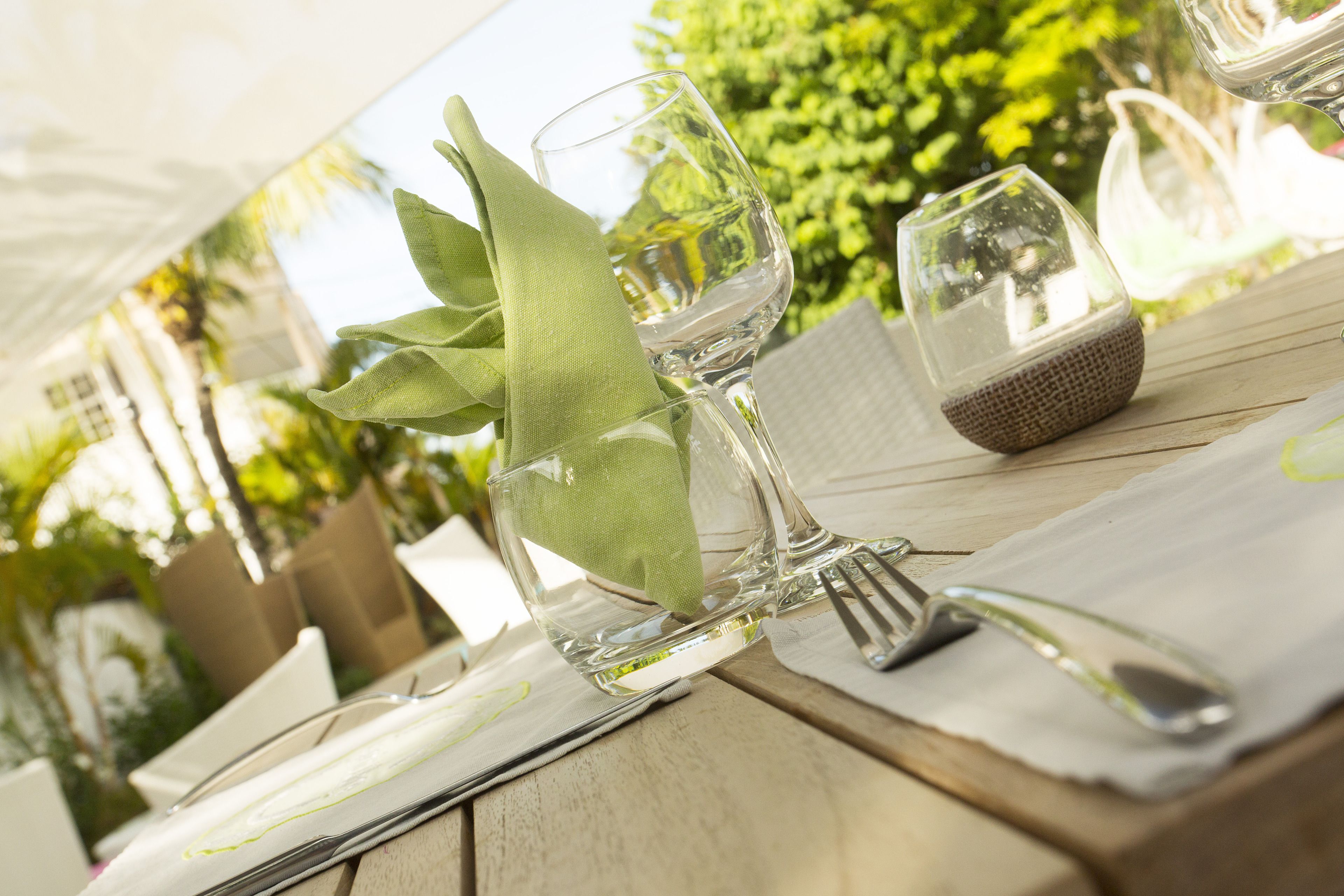 Une table dressée avec un verre à vin, une serviette et des couverts.